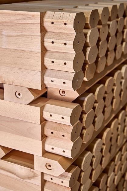 Une énorme pile de pieds de tables simples en bois de hêtre massif se dresse dans un atelier de menuiserie