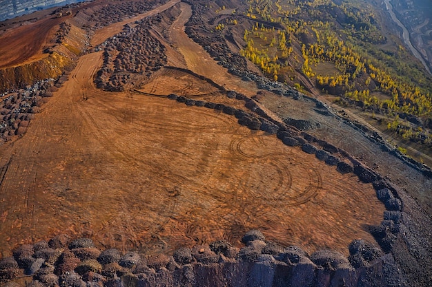 D'énormes monticules de déchets de minerai de fer près de la carrière. Camions Belaz conduisant dans une usine minière, carrière de mine en Ukraine