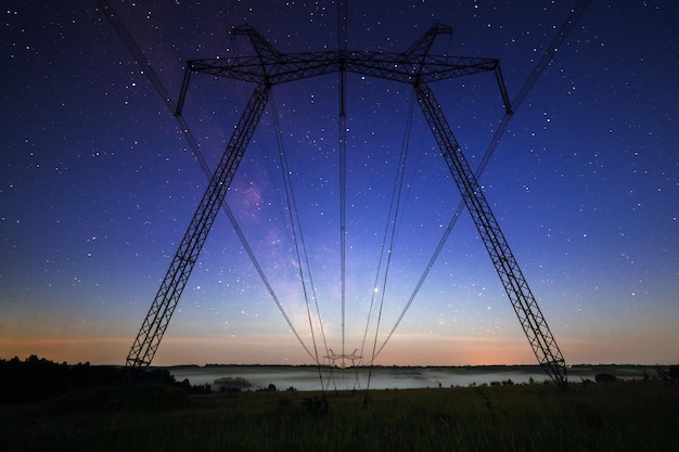 D'énormes pylônes électriques sur le terrain le soir d'été