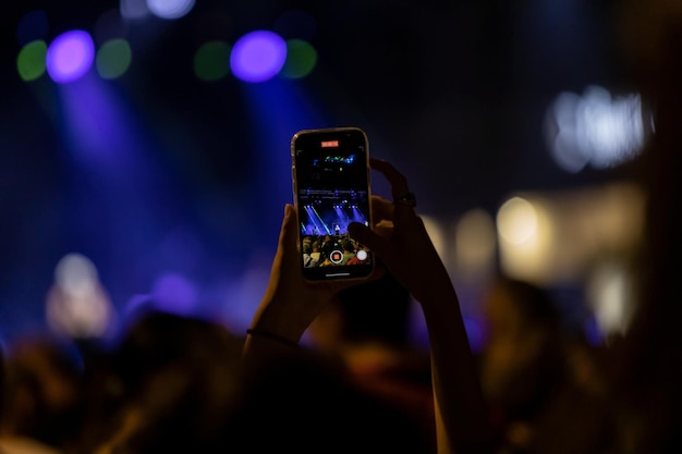 Enregistrement d'un concert avec une silhouette de mains avec un smartphone