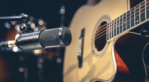 Photo enregistrement de guitare acoustique et microphone dans un studio de musique