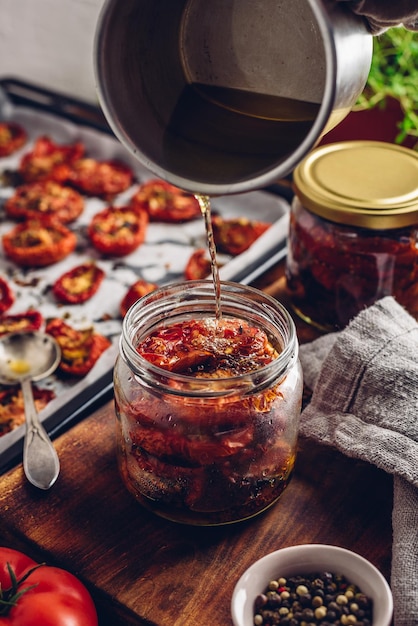 Enrobage de tomates séchées au soleil avec de l'huile d'olive dans un bocal