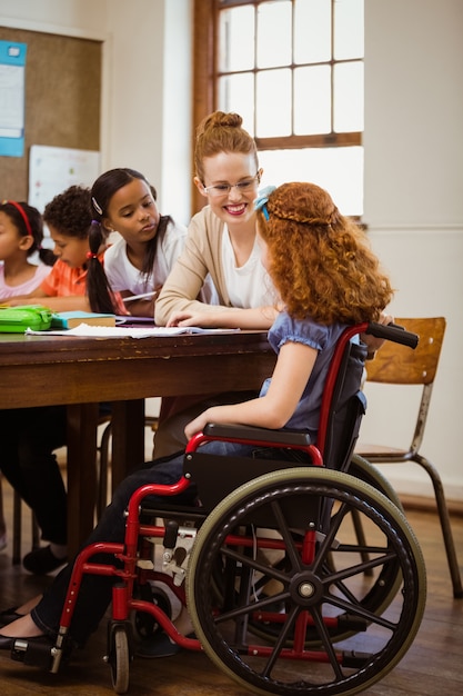 Enseignant aidant un élève handicapé