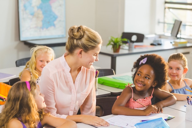 Enseignant aidant les enfants à faire leurs devoirs en classe