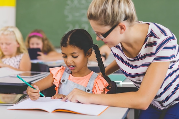 Enseignant aidant les enfants à faire leurs devoirs en classe