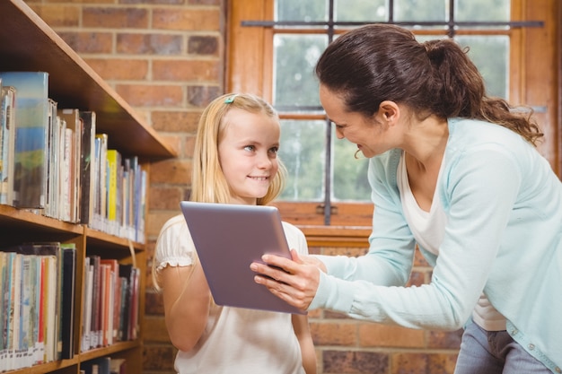 Enseignant aidant un étudiant à utiliser une tablette