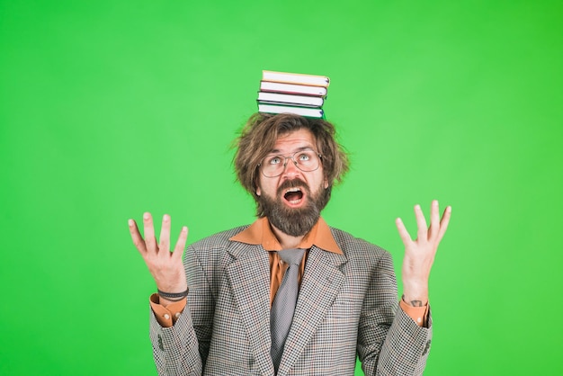 Photo un enseignant barbu a confondu un enseignant avec des livres sur la tête d'un homme barbu en costume d'éducation de retour à l'école