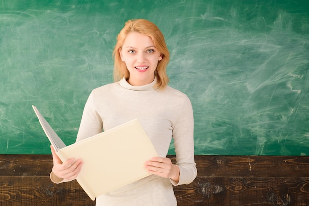 L'enseignant dans l'école en classe de retour à l'école L'enseignant de l'école en classe vérifie le travail d'éducation des manuels