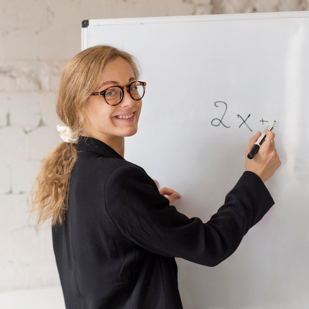 Enseignant écrit sur tableau blanc