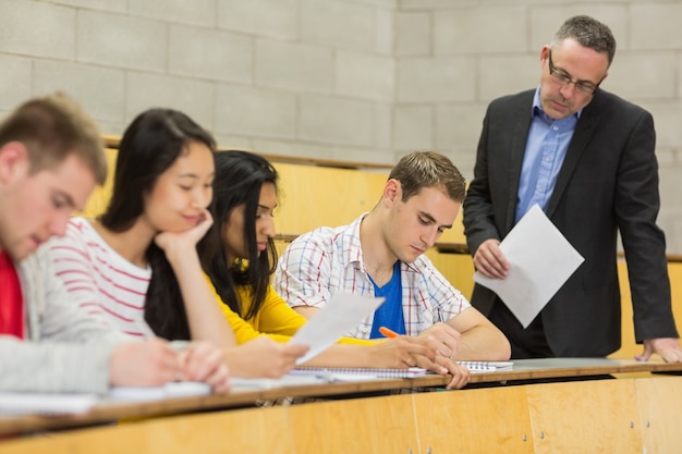 Enseignant avec des élèves qui écrivent des notes dans la salle de conférence