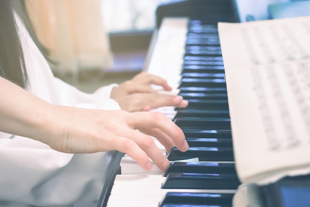 Enseignant enseignant à une petite fille à jouer du piano Concept d'étude de la musique et de passe-temps créatif