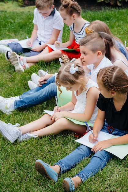 Un enseignant enseigne à une classe d'enfants dans un parc extérieur. Retour à l'école, apprentissage pendant la pandémie.