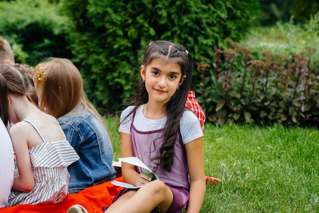 Un enseignant enseigne à une classe d'enfants dans un parc extérieur. Retour à l'école, apprentissage pendant la pandémie.