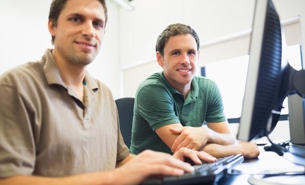 Photo enseignant et étudiant adulte en salle informatique