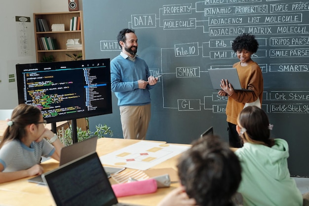 L'enseignant explique les concepts de programmation aux élèves engagés