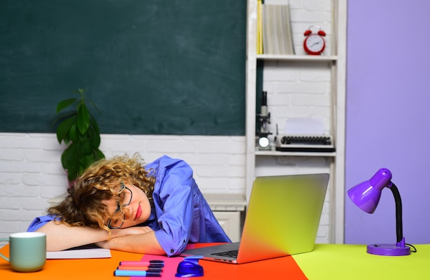 Enseignant fatigué dormant dans la salle de classe travail acharné enseignant du travail scolaire se préparant aux examens universitaires