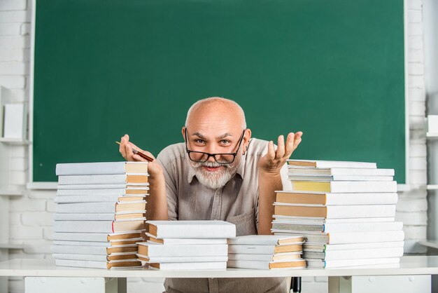 Enseignant avec des livres à l'école Enseignant d'école primaire debout dans la salle de classe