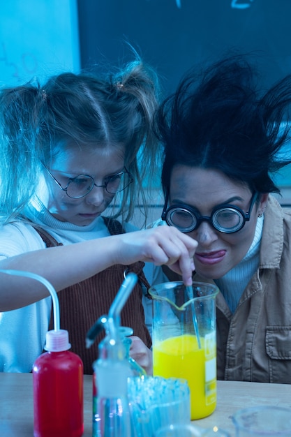 Photo enseignant et petite fille pendant la leçon de chimie mélangeant des produits chimiques