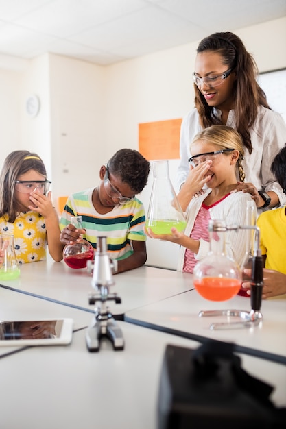 Photo un enseignant regarde les élèves faire de la science