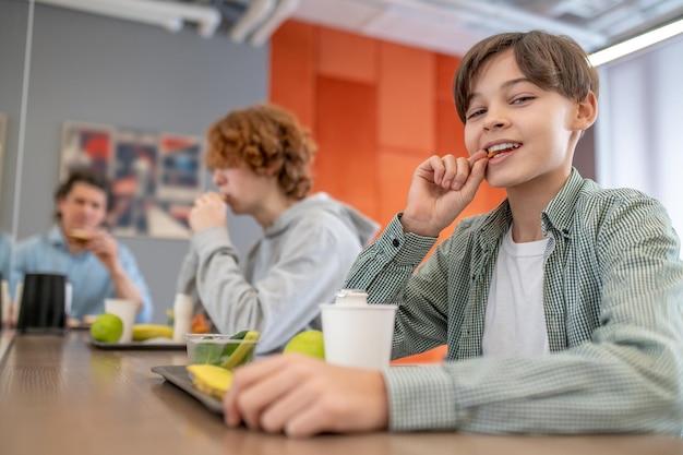 Un enseignant et ses élèves en train de déjeuner à la cantine scolaire