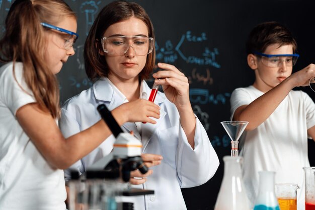 L'enseignant soutient l'expérience de l'étudiant liquide dans un tube en laboratoire Erudition