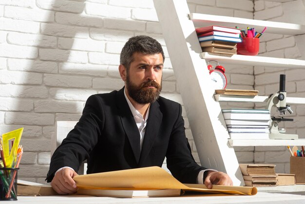 Enseignant travaillant au bureau. Portrait d'un enseignant, d'un professeur, d'un tuteur, d'un mentor pensant dans une salle de classe.