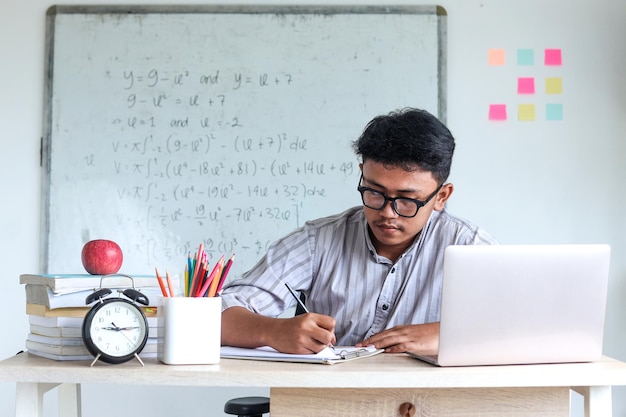 Enseignant travaillant en classe écrivant des notes sur la table préparant le plan de leçon