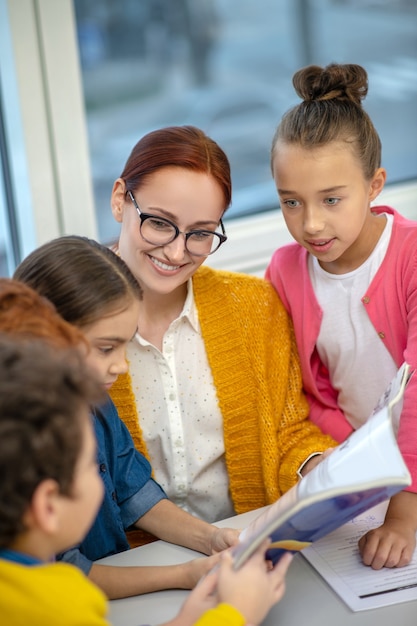 L'enseignant travaillant avec un petit groupe d'enfants