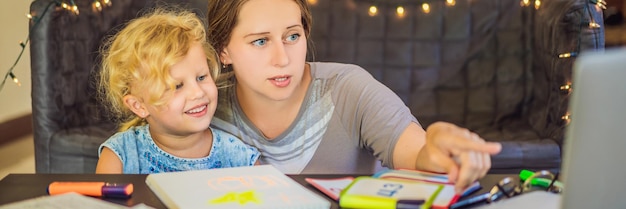 Un enseignant un tuteur pour l'enseignement à domicile et un enseignant à table Ou maman et sa fille L'enseignement à domicile