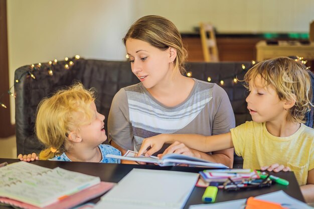 Enseignant tuteur pour l'enseignement à domicile Garçon et fille à table Ou mère fille et fils Enseignement à domicile