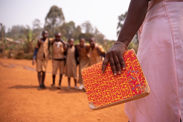 Photo une enseignante africaine tient un livre avec ses élèves flou dans le concept d'arrière-plan de l'éducation en afrique