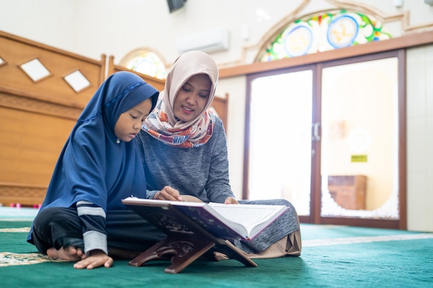 Une enseignante apprend à son élève à lire le Coran