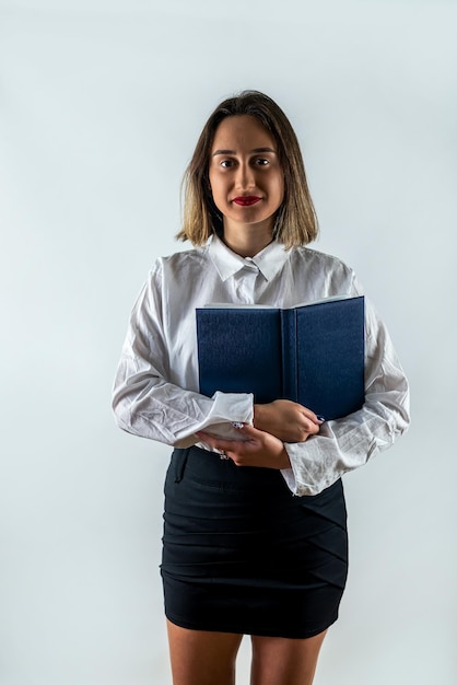 Enseignante confiante jeune femme d'affaires tenant debout avec des livres dans les mains