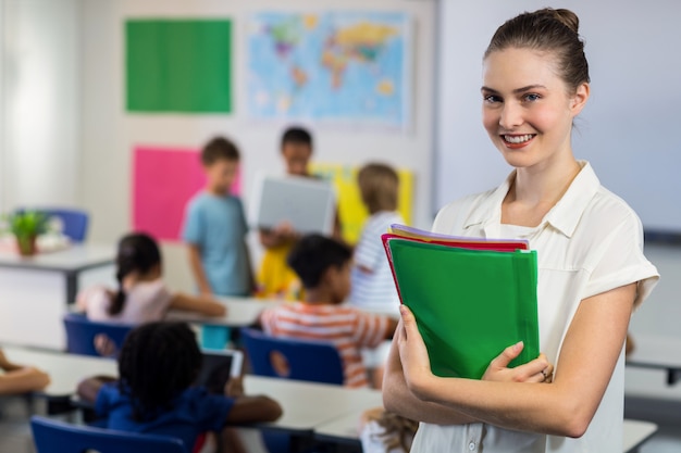 Enseignante, à, dossiers, debout, dans, classe