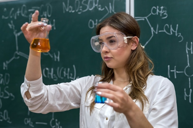 Enseignante effectuant une expérience avec du liquide dans un flacon pendant la leçon. La science est intéressante et fascinante