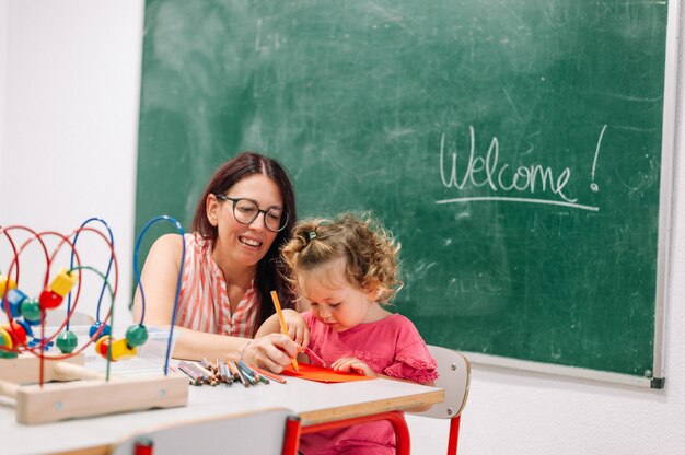 Photo une enseignante de maternelle soutient l'enfant en classe