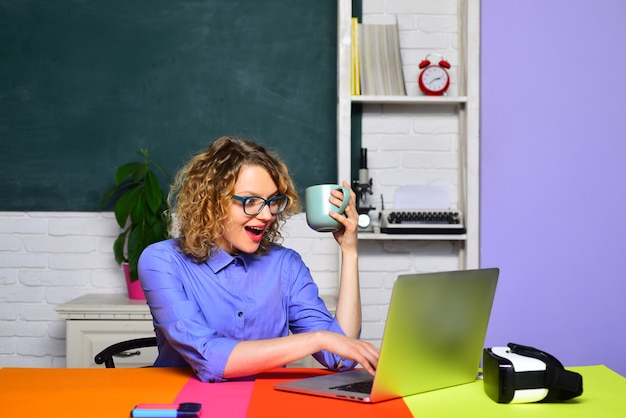 Enseignante près du tableau noir jeune étudiante souriante étudiant à l'école, étudiante heureuse ou