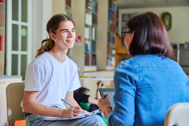 Une enseignante psychologue scolaire parle et aide un étudiant adolescent