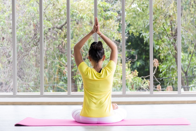 Une Enseignante De Yoga Asiatique Portant Une Chemise Jaune Entraîne Son Corps