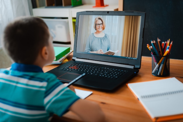 Enseignement à distance en ligne. Un écolier étudie à la maison et fait ses devoirs. Un apprentissage à distance à domicile