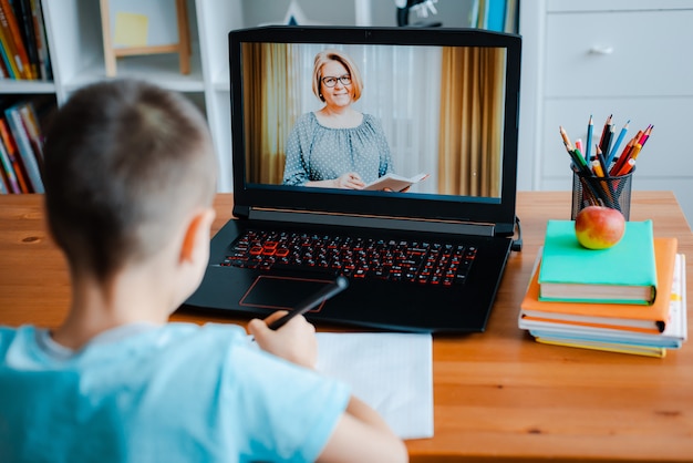 Enseignement à distance en ligne. Un écolier étudie à la maison et fait ses devoirs. Un apprentissage à distance à domicile