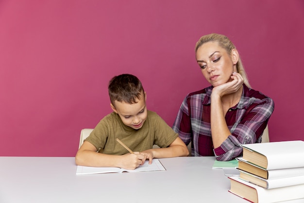 L'enseignement à distance. La mère aide l'enfant d'âge préscolaire à faire des leçons. Éducation au moment de la quarantaine