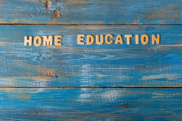 L'enseignement à domicile d'inscription est composé de petits blocs de bois imprimés sur un fond bleu en bois avec espace de copie. Mise en page, vue de dessus