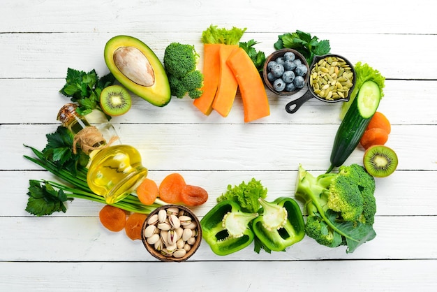 L'ensemble des aliments riches en vitamine E citrouille brocoli abricots secs persil avocat et légumes vue de dessus style rustique