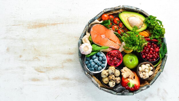 Ensemble d'aliments sains dans une boîte en bois légumes fruits poisson viande noix et herbes Vue de dessus Espace de copie gratuit