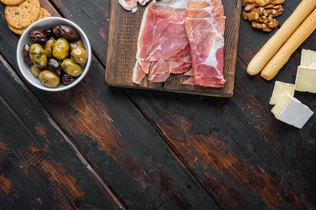 Ensemble d'antipasti italien classique, sur table en bois sombre, mise à plat