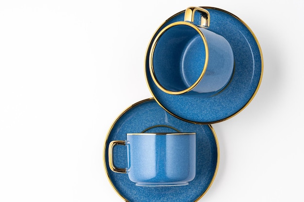 Un ensemble d'assiettes en céramique bleue et une tasse sur fond blanc Vue de dessus