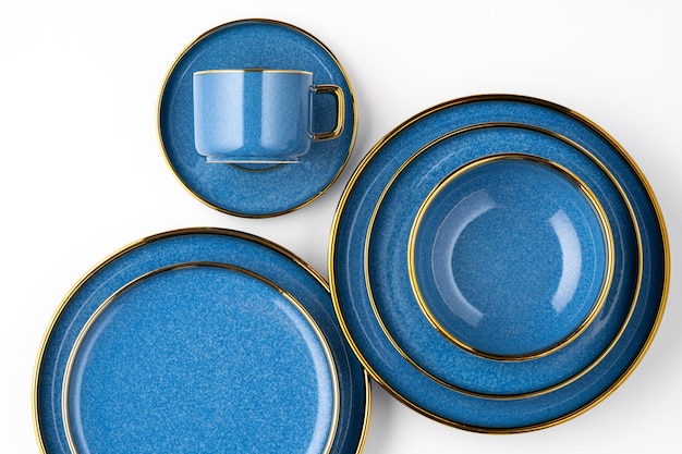 Photo un ensemble d'assiettes en céramique bleue et une tasse sur fond blanc vue de dessus