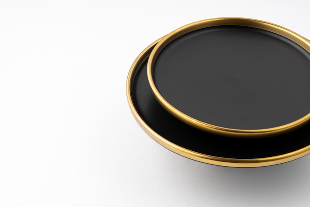 Un ensemble d'assiettes en céramique noire et dorée sur fond blanc