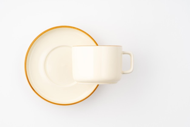 Un ensemble d'assiettes et de tasses en céramique blanche et brune sur fond blanc Vue de dessus